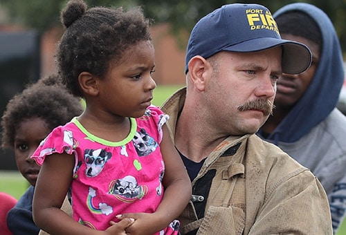 A first responder holding a child