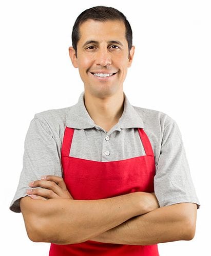 A smiling vendor wearing an apron.