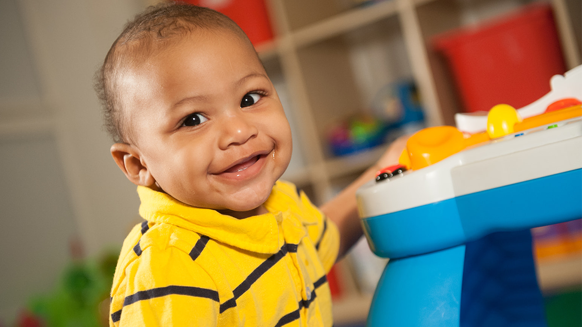 baby standing up and smiling