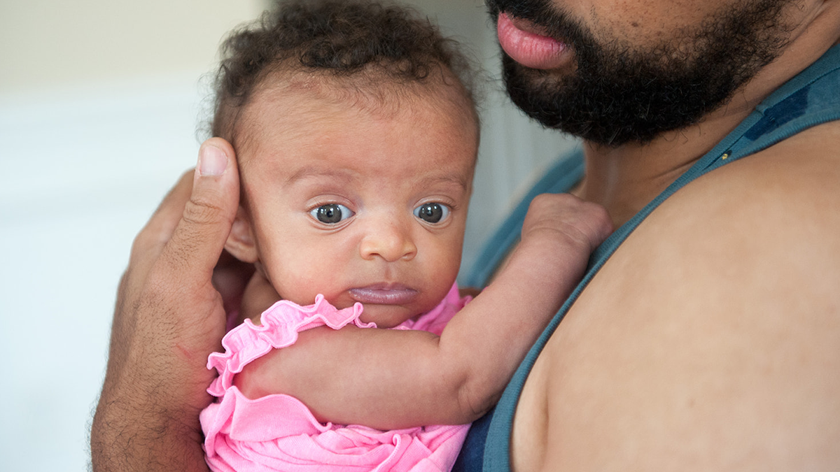 2-month-old baby being held by dad