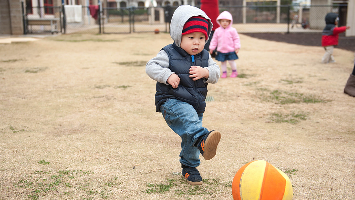 child kicking a ball