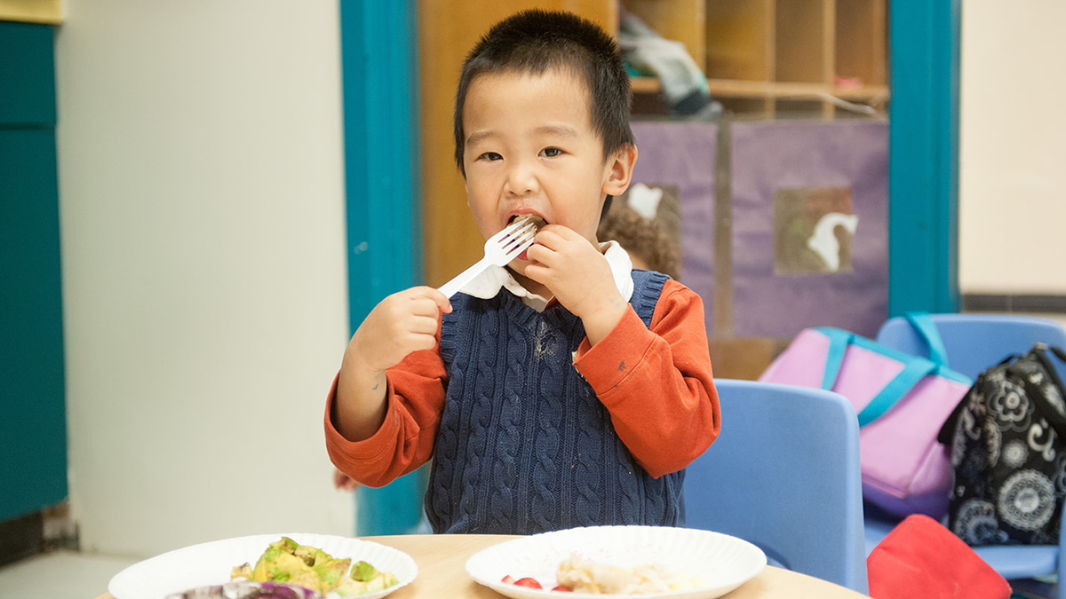 child feeding himself with fork