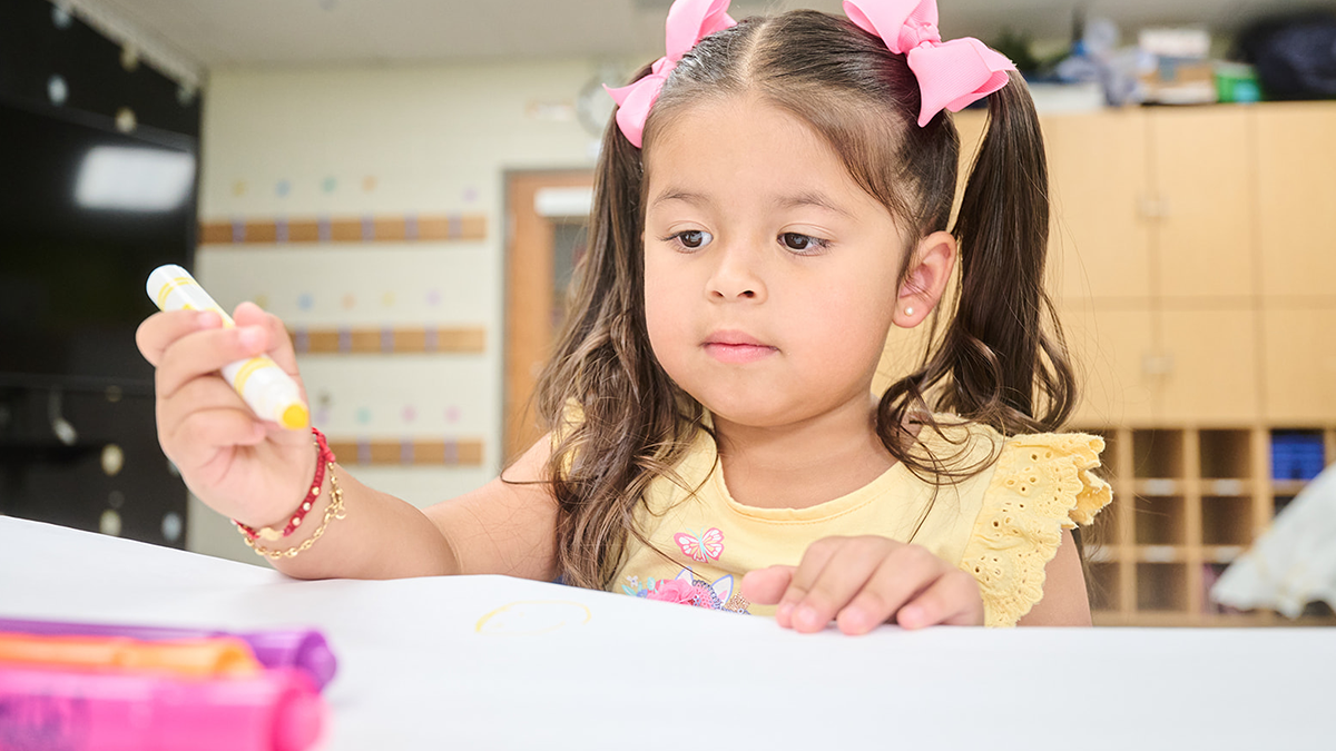 child holding marker and drawing