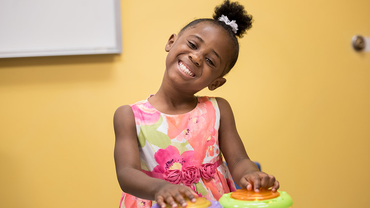 happy child playing drums smiling