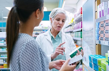 A pharmacist discussing medication with a customer.