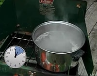A pot of boiling water with a clock showing a boil time of 10 minutes