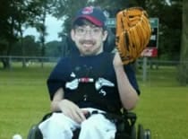 Zac posing in his wheel chair for his baseball team photo