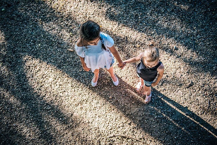 Two girls holding hands on playground