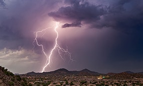 Lighting bolts touch the ground near a city