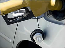 Photo of gasoline nozzle in car gas tank.