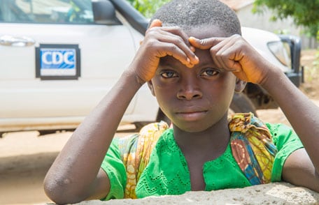 Young African boy in front of CDC van