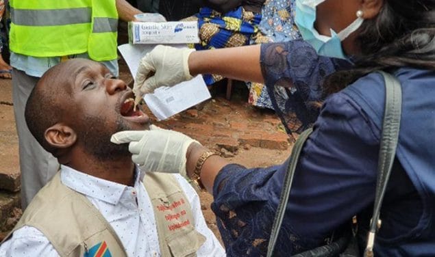 A vaccination team member receives oral cholera vaccine.