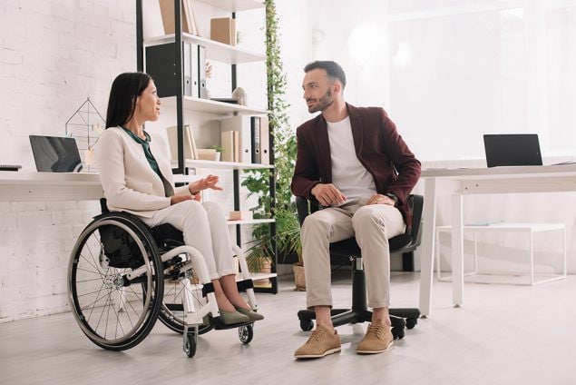 woman in wheelchair in a discussion with co-worker