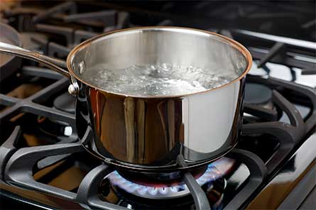 Imagen de una olla con agua hirviendo en estufa de gas