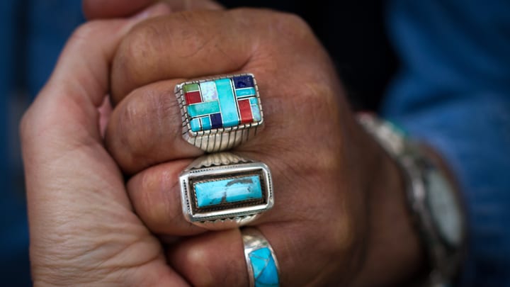 View of a handshake featuring rings with Native American design