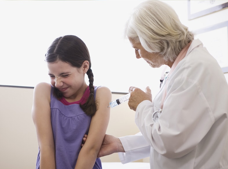 A doctor administering a vaccination to a young girl.
