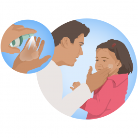 Adult applying insect repellent to a child’s face.