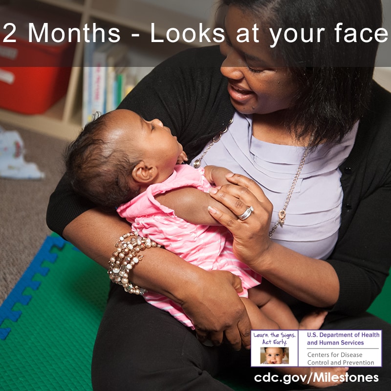 The baby in this photo is looking at her mother’s face, a 2-month social/emotional milestone.