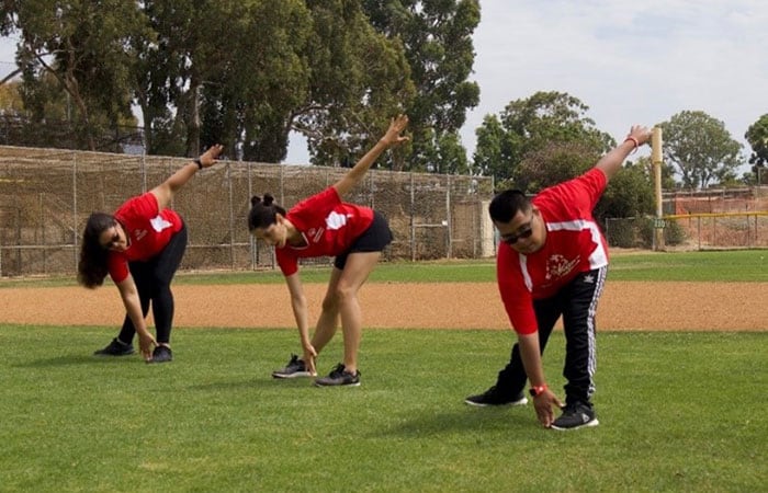 Athletes stretching on a baseball field
