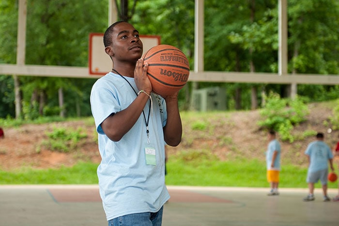 Boy shooting basketball at a park