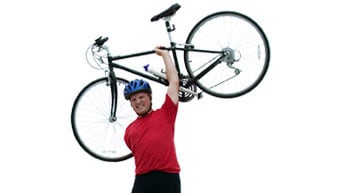 A disabled man holding a bike over his head