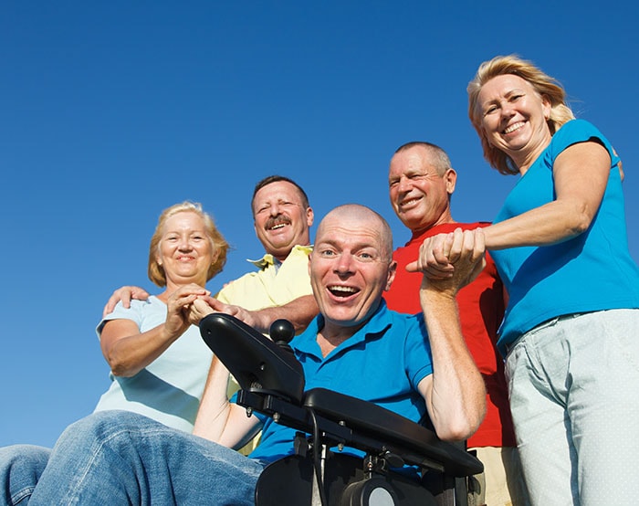 Man in wheelchair with family outside