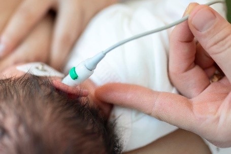 Newborn receiving a hearing screening.
