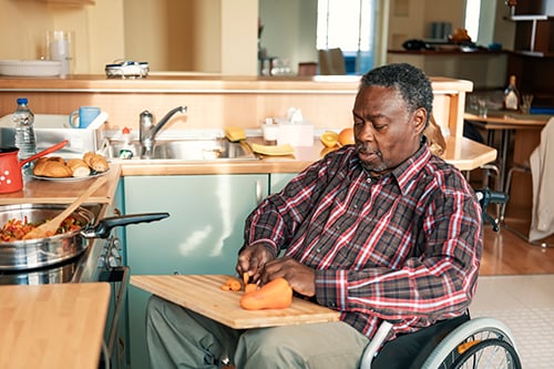 Man in a wheelchair preparing food