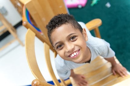 Boy laying across a chair, looking up