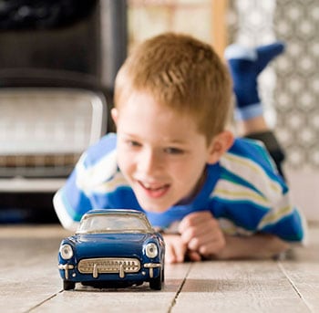 Young boy playing with a toy car