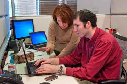 Man and woman at work looking at a computer.