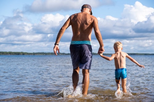 Padre e hijo caminando en el agua