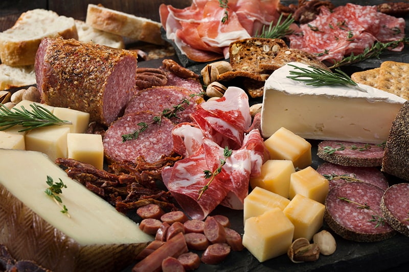 Charcuterie board with various meats and cheeses