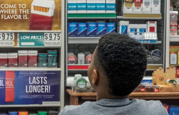 Child facing a store shelf of tobacco products.