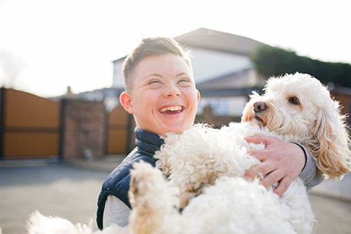 Smiling boy holding his dog