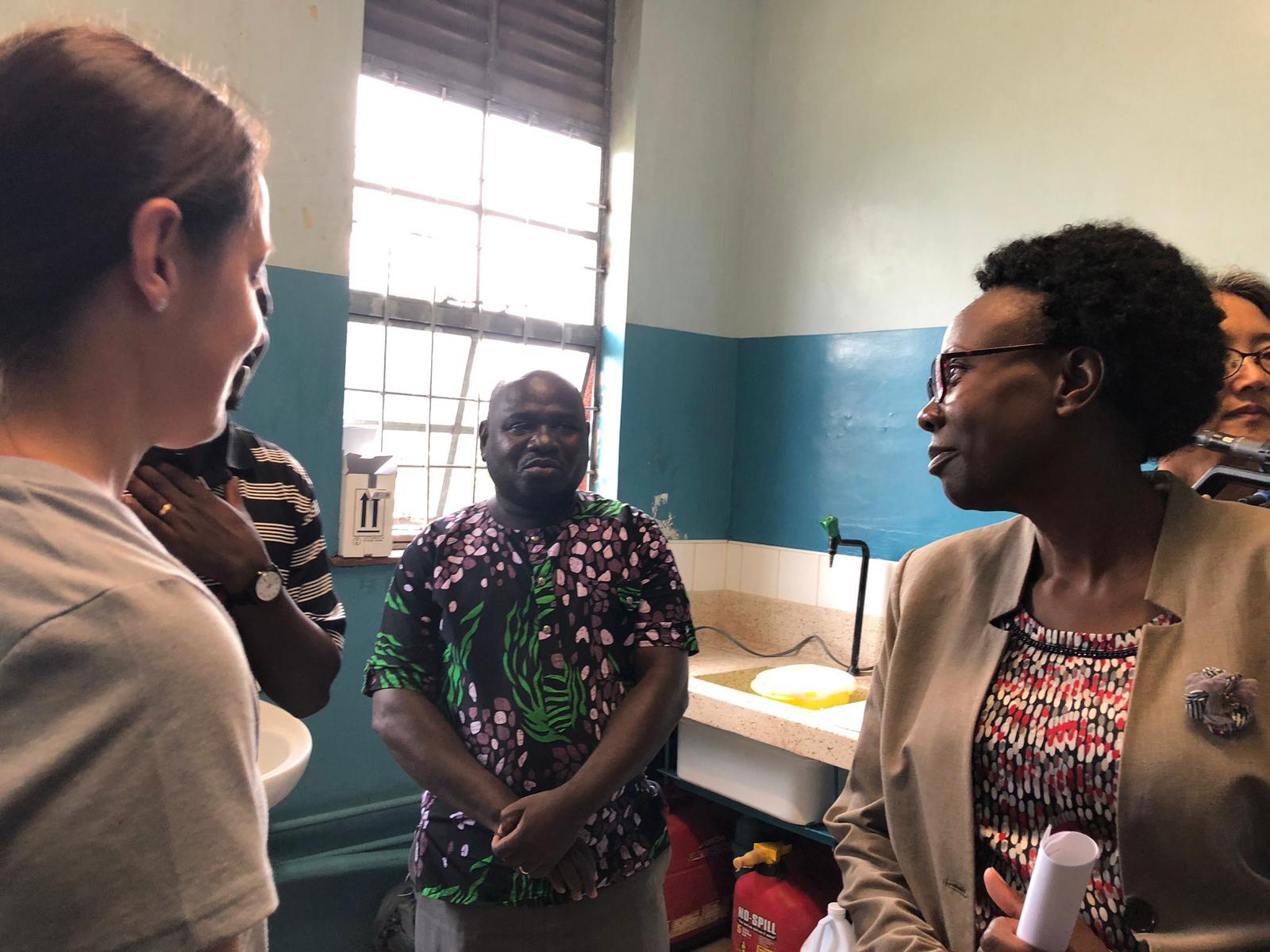 Amy Schuh, Luke Nyakarahuka, and Jackson Kyondo show the Ugandan Minister of Health the Ebola field laboratory in Bwera, Uganda