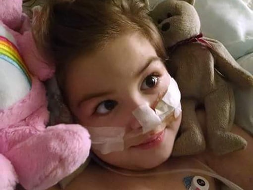 Kaitlin surrounded by stuffed animals in her hospital bed