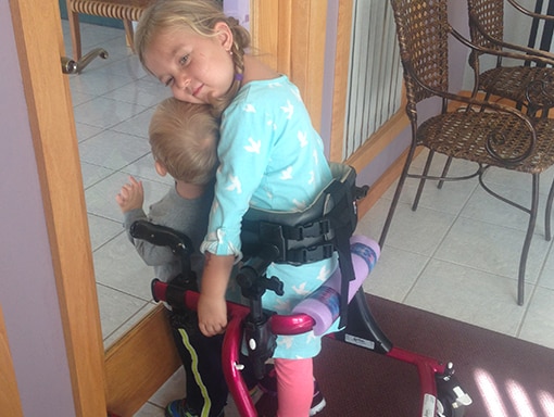Laura and her brother in her wheelchair.