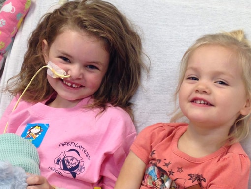 Lauren smiling in the hospital with her sister.