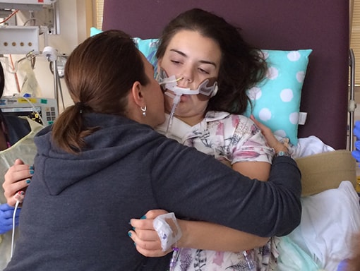 Mom gives Sarah a hug while in recovery