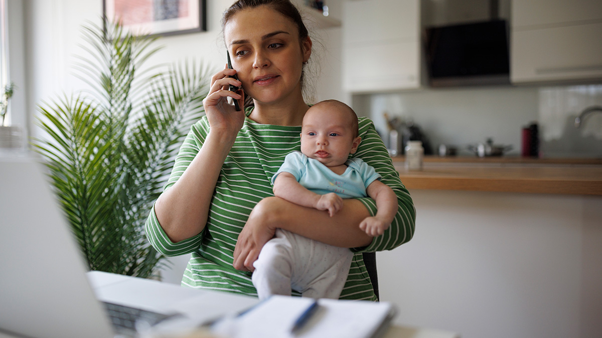 Mom holding baby while talking on the phone