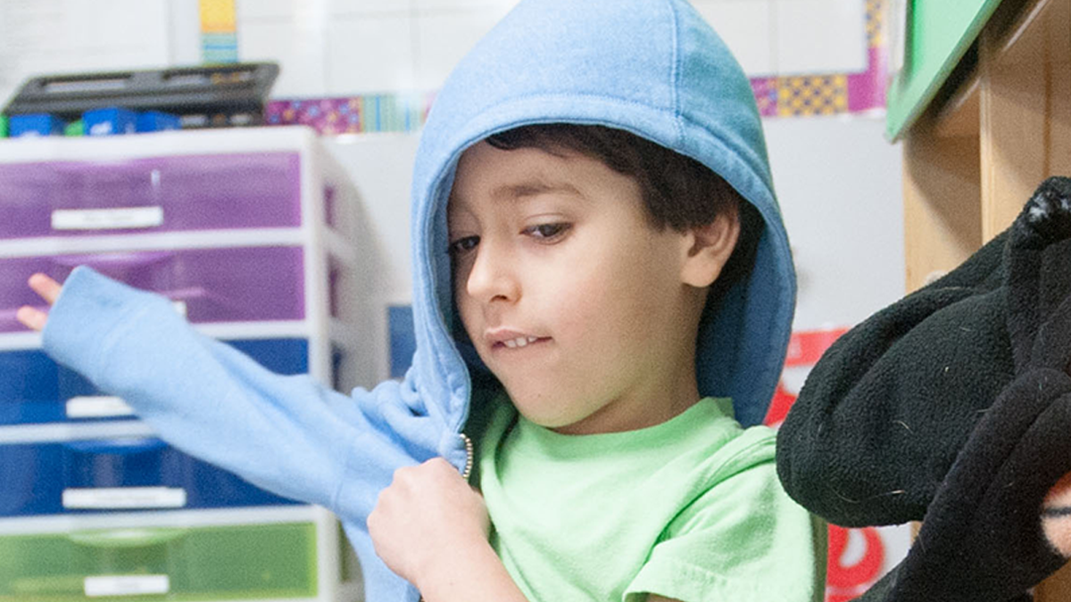 3 years old child putting on jacket