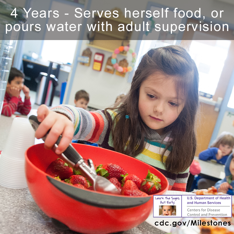 The girl wearing a striped shirt is scooping up strawberries by herself.