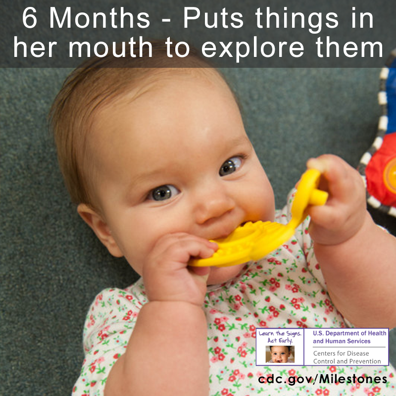 Baby putting yellow object into mouth while laying on ground