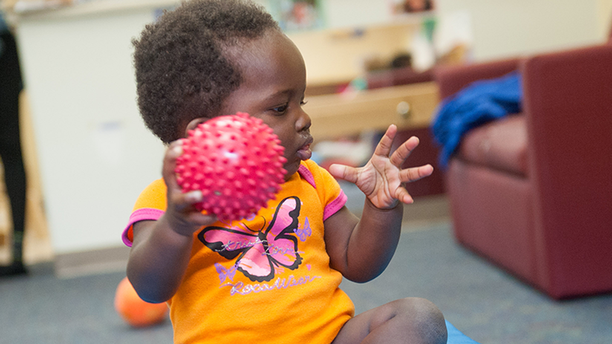 9 month old child playing with ball