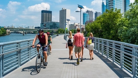 People walking and biking across a bridge.