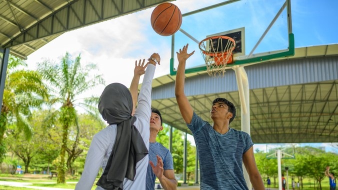 Three people playing basketball.