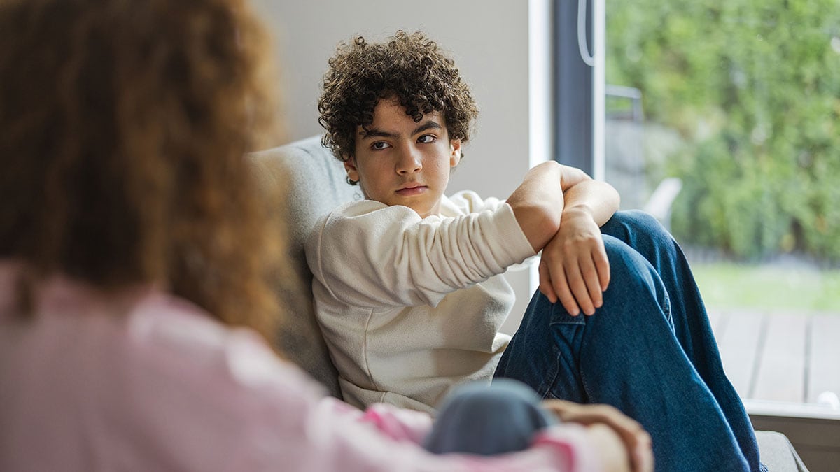 Son sitting on couch staring at his mother.