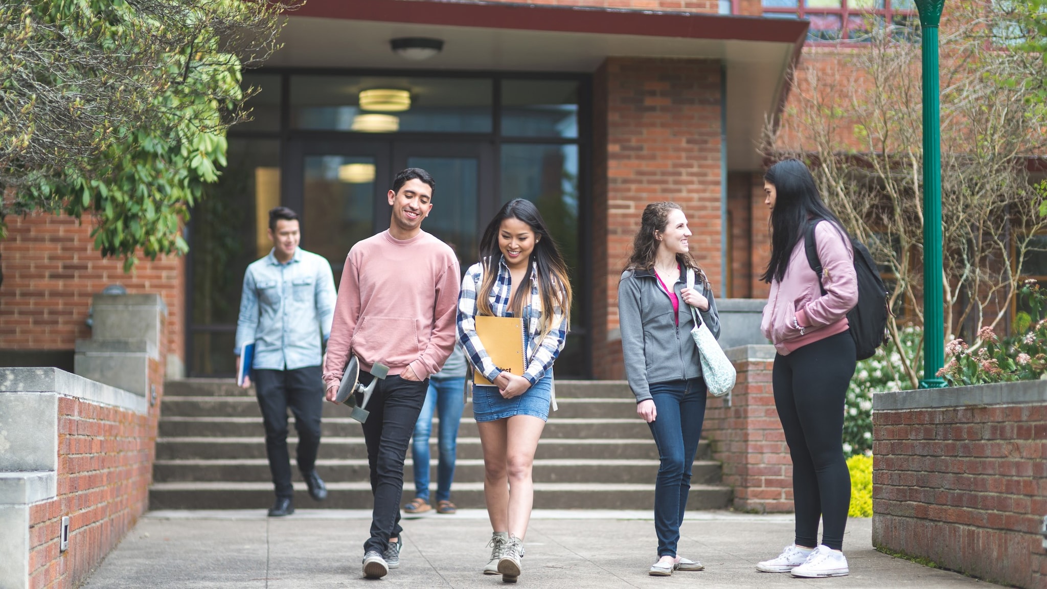 Groups of students talking outside of school.