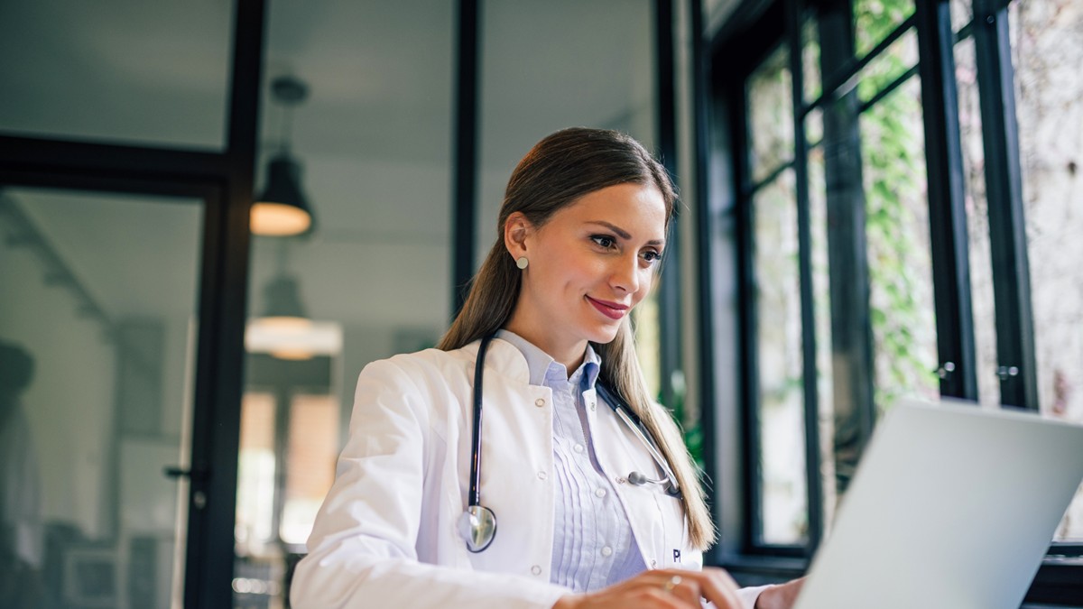 A healthcare provider looking at her computer and taking a continuing education course.